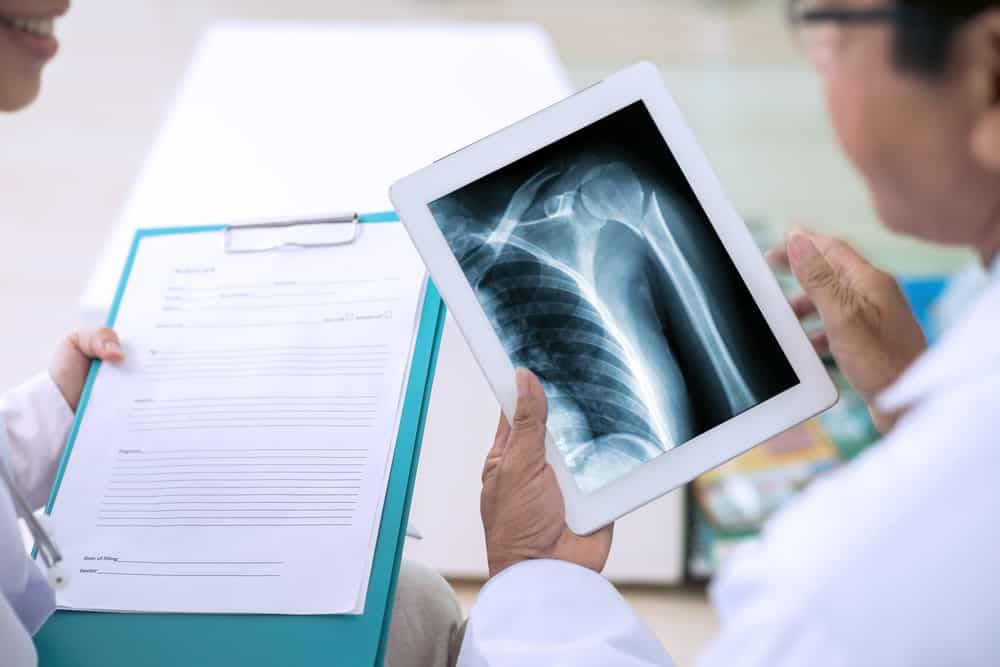 Technician performing a home X-ray for an elderly patient in Bandra